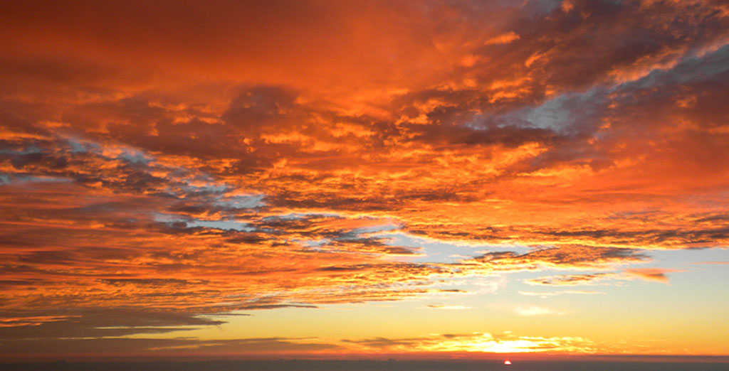 Orange sunrise with dramatic orange clouds.